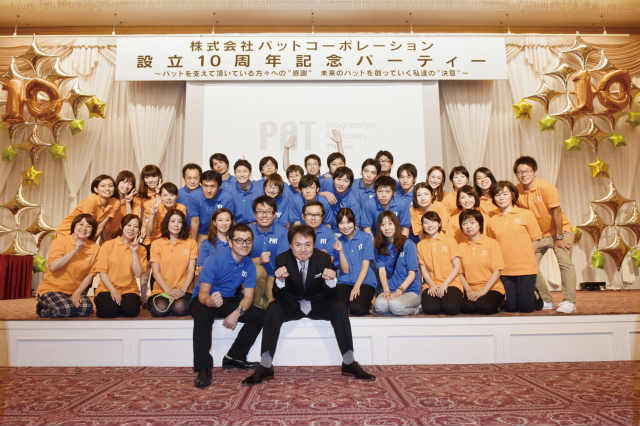 同社の設立10周年パーティでの集合写真。尾崎社長を囲んで。